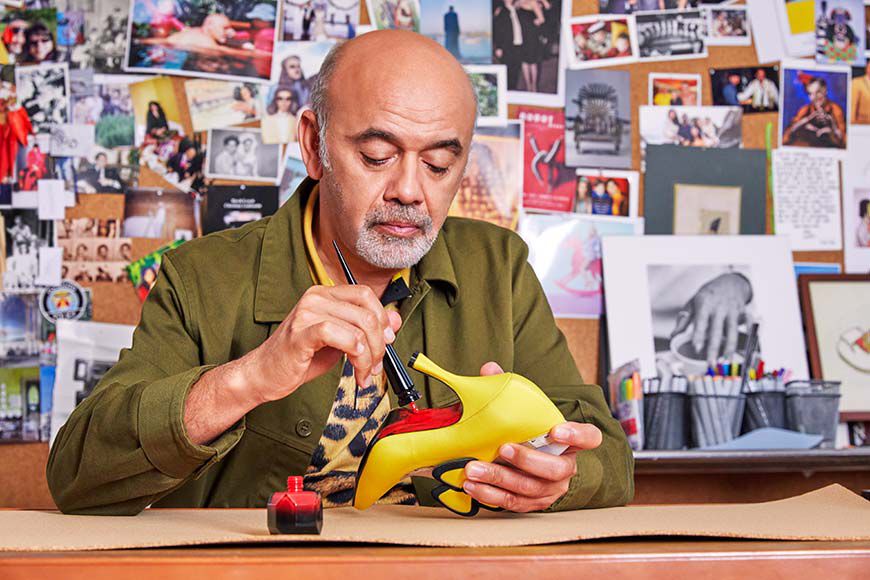 Mr. Louboutin applying red nail polish to the sole of a prototype shoe
