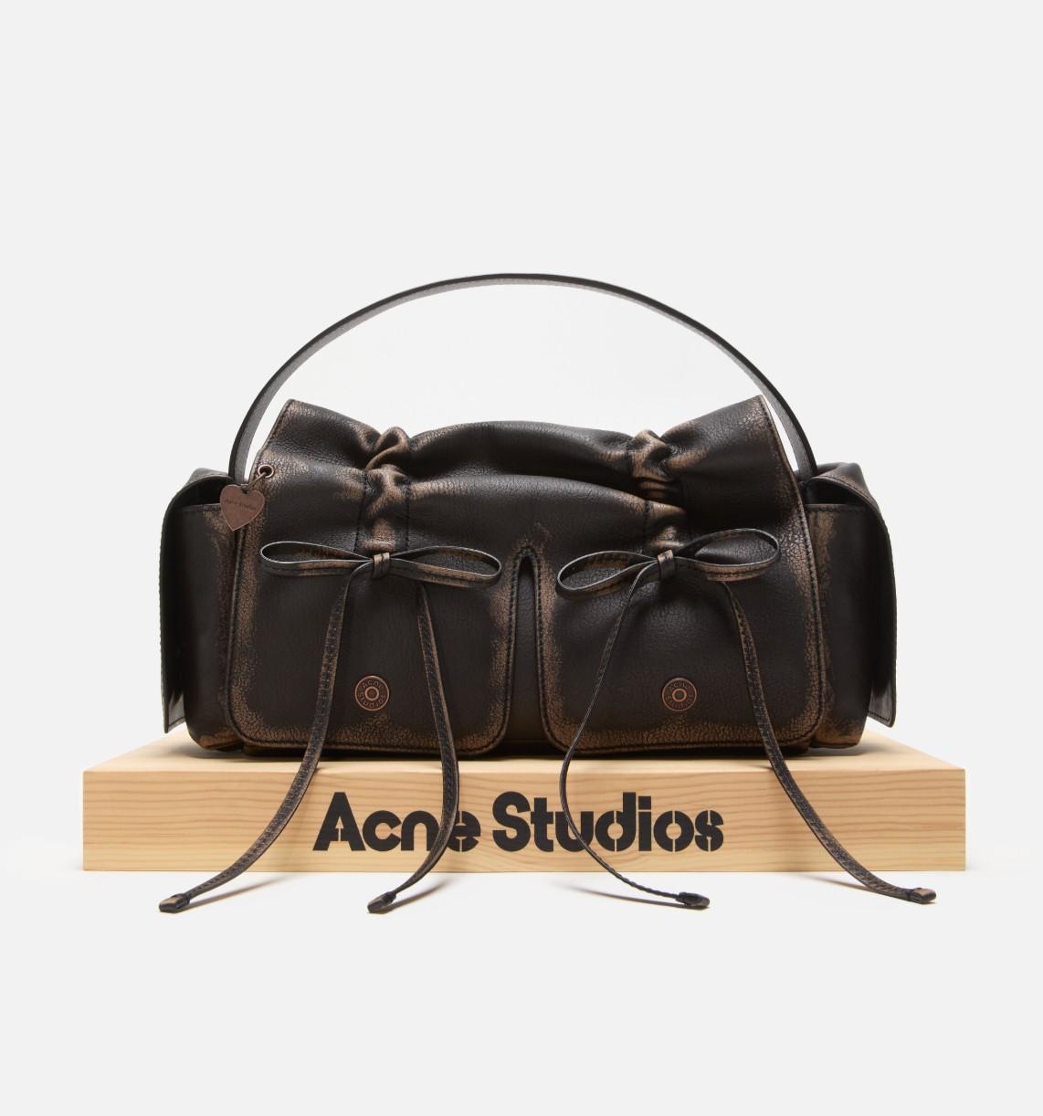 Acne Studios multipocket bag with knotted lacing and jeans-inspired rivets on the pockets and side flap pockets with a discrete magnetic closure, spacious interior and adjustable shoulder strap.