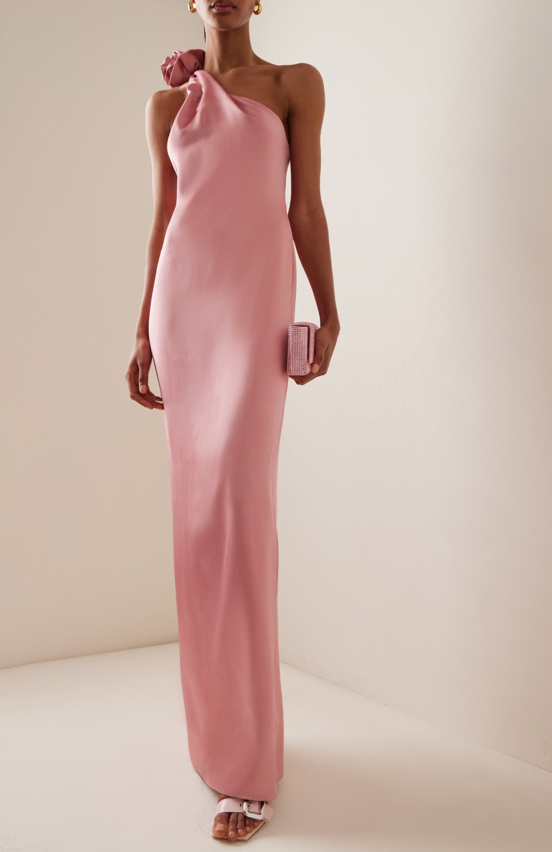 The Magda Butrym Rose-Detailed One-Shoulder Silk Dress in dusty pink featuring a twisted neckline and handcrafted rosette.